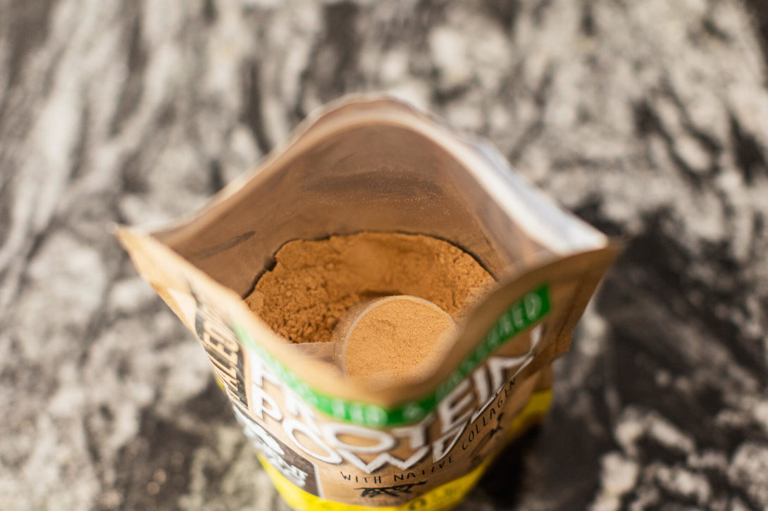 Open bag of whey protein with scoop visible